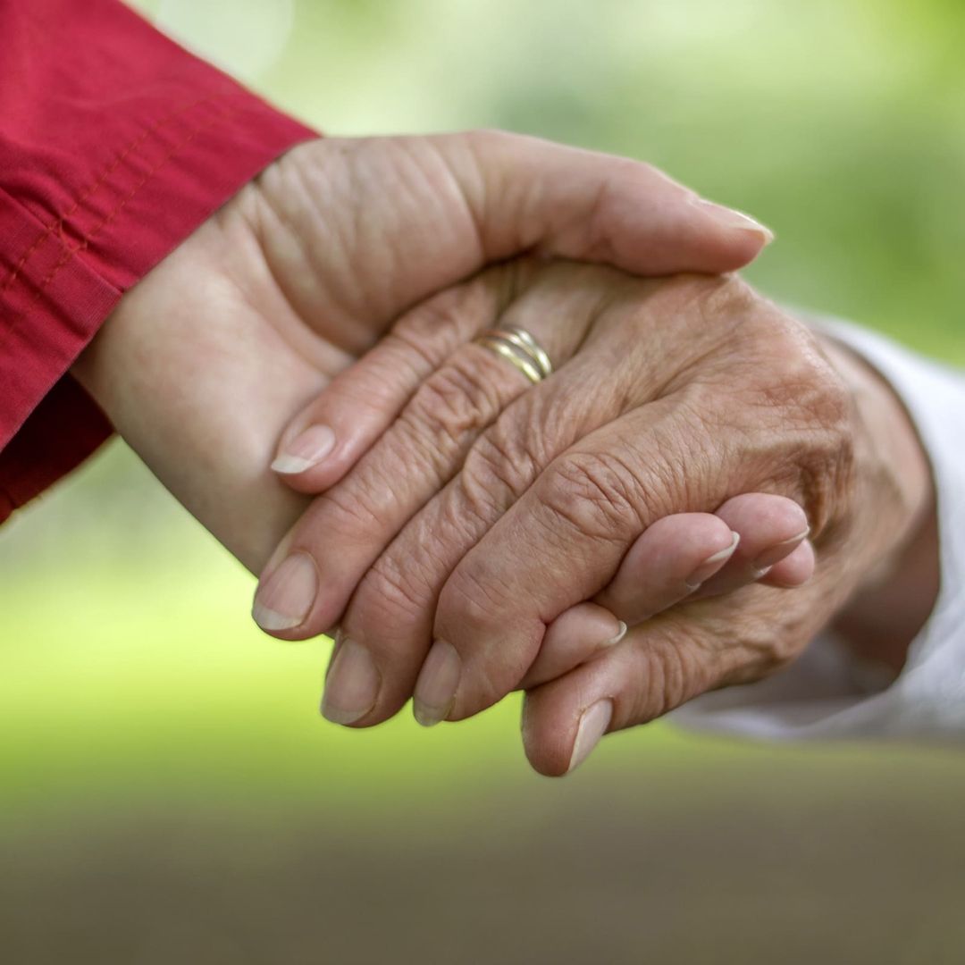 Eine junge Hand hält eine ältere Hand