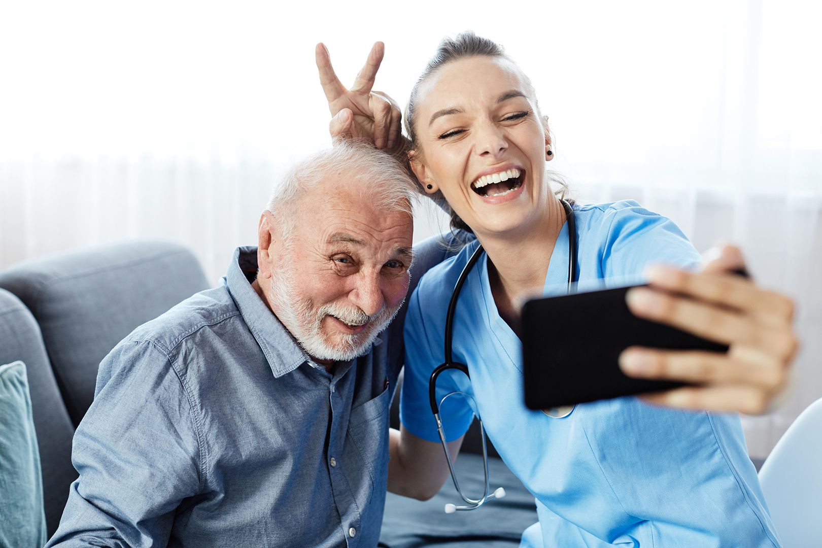 Eine-Pflegekraft-und-ein-älterer-Mann-machen-ein-Selfie