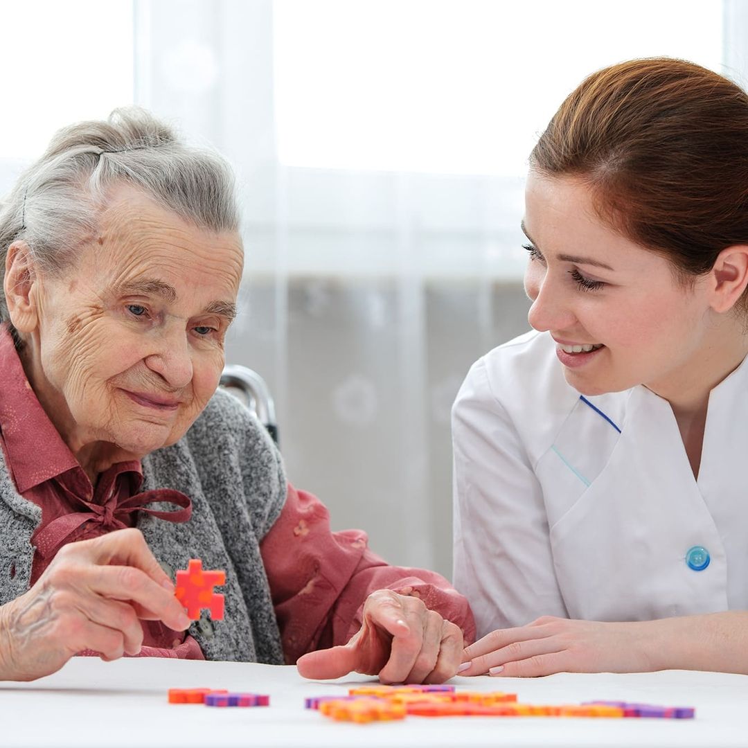 Pflegerin und eine ältere Dame puzzeln